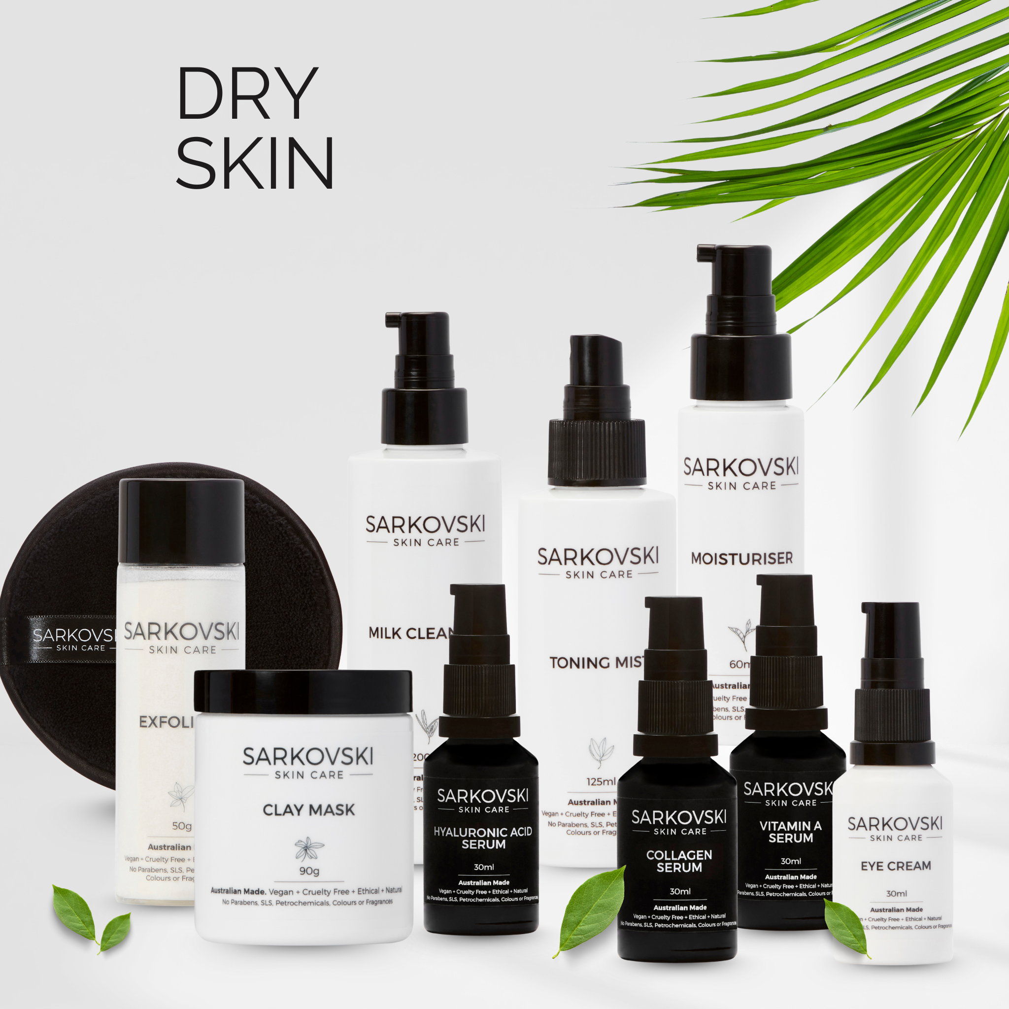 SARKOVSKI® Dry Skin Collection featuring Milk Cleanser, Toning Mist, Moisturiser, Hyaluronic Acid Serum, Collagen Serum, Vitamin A Serum, Clay Mask, Exfoliant, Cleansing Cloth and Eye Cream displayed with fresh green leaves.
