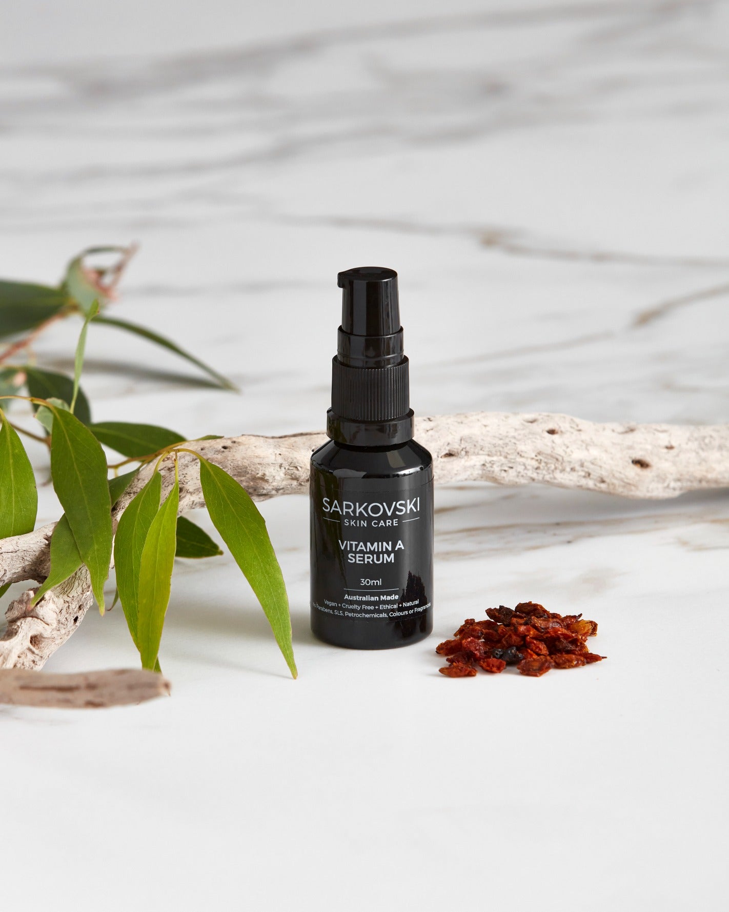a photo SARKOVSKI® Vitamin A Serum 30mL, with dried wooden stick and berries with fresh leaves. SARKOVSKI® Vitamin A Serum 30mL, natural Australian skincare, a potent, plant-based formula designed to combat sun damage, acne, and signs of premature aging. 